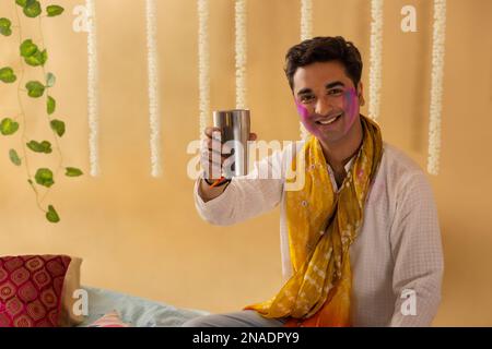 Un giovane che beve un bicchiere di bhang in festa holi Foto Stock