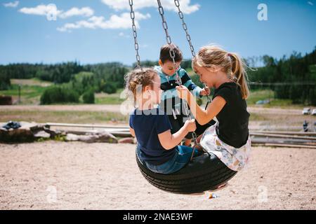 I bambini si stancano sul playset in montagna sotto il sole Foto Stock