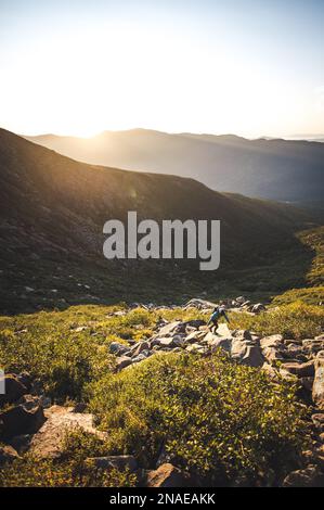 Donna escursioni tra massi all'alba in montagne bianche Foto Stock