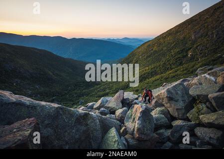 Donna escursioni tra massi all'alba in montagne bianche Foto Stock