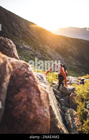 Donna escursioni tra massi all'alba in montagne bianche Foto Stock