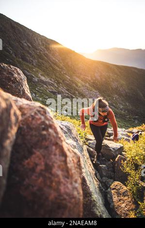 Donna escursioni tra massi all'alba in montagne bianche Foto Stock