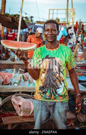 Mwanza, Tanzania - 05.01.2022 - uomo africano che vende anguria sul mercato Foto Stock