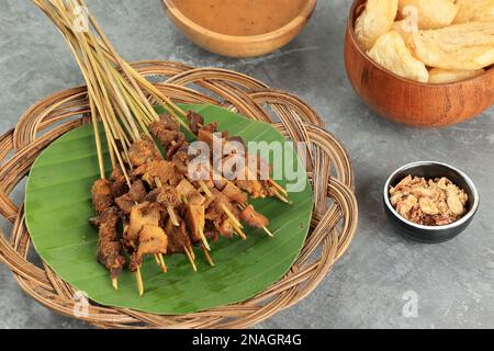 Sate Padang tradizionale cibo di manzo Satay da Padang Indonesia, servito con Lontong o Ketupat e giallo speciale salsa di condimento Foto Stock