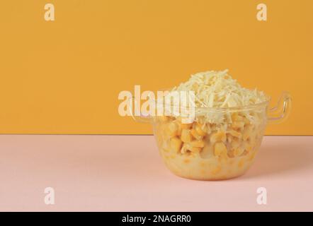 Mais cremoso con formaggio grattugiato, popolare come Jagung Susu Keju o Jasuke. Mais al vapore con latte condensato Foto Stock