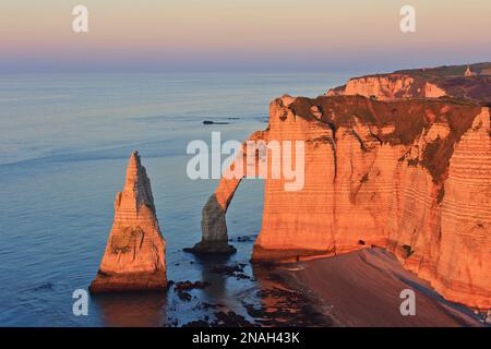 La Porte d'Aval (arco) e la formazione appuntita noto come l'ago (l'Aiguille) a Etretat (Senna Marittima), Normandia, Francia al tramonto Foto Stock