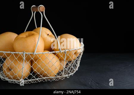 Pere di mela mature nel cestino sul tavolo nero. Spazio per il testo Foto Stock