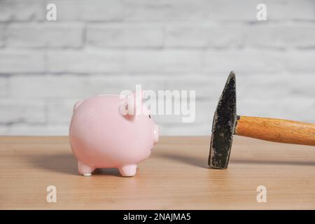Banco e martello piggy - concetto di rottura o frantumazione piggybank o banca di moneta per saccheggio di risparmi Foto Stock