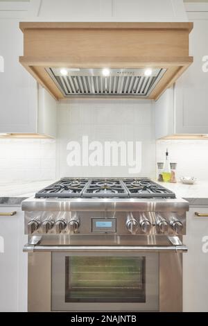 Gamma gas inox e cappa in legno in cucina moderna Foto Stock