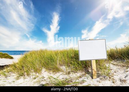 segnavia con spazio di copia su ampia spiaggia di sabbia contro il mare e cielo blu Foto Stock
