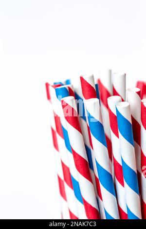 Cannucce di carta multicolore per bevande da vicino su sfondo bianco. Foto Stock
