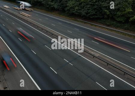 Primo piano dell'autostrada M40 nel Buckinghamshire, Regno Unito. La fotografia a lunga esposizione produce veicoli sfocati e tracce di luce utilizzando una velocità dell'otturatore ridotta. Foto Stock