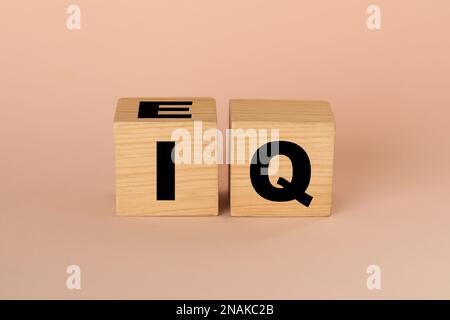 Cubi di legno con abbreviazione IQ su sfondo beige Foto Stock