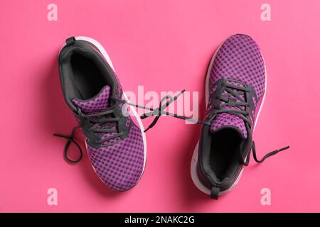 Sneaker eleganti con lacci neri su sfondo rosa e giacitura piatta Foto Stock