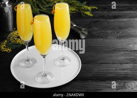 Bicchieri di cocktail Mimosa con decorazione su tavolo di legno scuro. Spazio per il testo Foto Stock