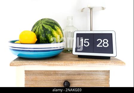 2020-08-31 Amburgo, Germania: Google Nest Hub Smart display e altoparlante intelligente su mensola cucina con melone e limoni d'acqua in ciotola di frutta Foto Stock