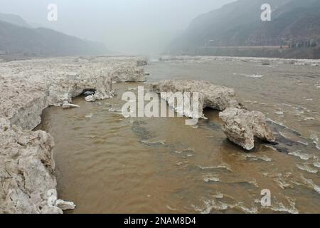 LINFEN, CINA - 12 FEBBRAIO 2023 - Foto aerea scattata il 12 febbraio 2023 mostra la cascata Hukou del Fiume giallo nella contea di Jixian, Linfen città, Nord Foto Stock
