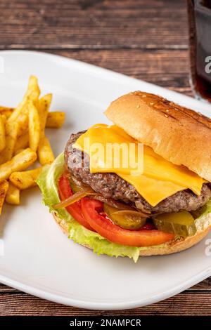 Cheeseburger con pomodori e Pickles con patatine fritte e ketchup Foto Stock