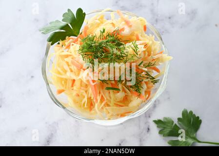 Crauti fatti in casa con carote, aneto in un piatto su sfondo chiaro. Cibi fermentati. Un prebiotico naturale. Foto Stock