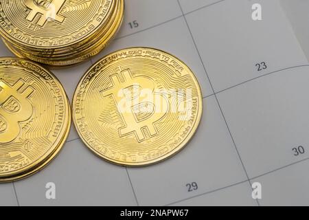 Business , denaro, tecnologia e criptovaluta concetto di investimento. Primo piano della pila di monete d'oro bitcoin su calendario pianificatore. Foto Stock