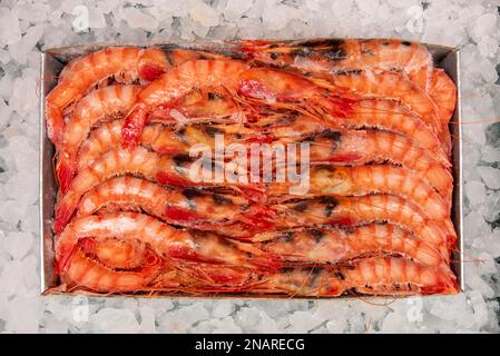 Una scatola da ottocento grammi di gamberi di tigre congelati su ghiaccio tritato Foto Stock