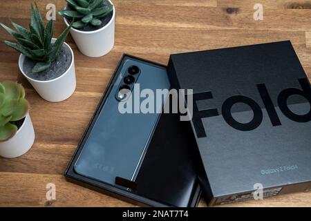 Budapest, Ungheria - 05 gennaio 2023. Nuovissimo Samsung Galaxy Z Fold 4 in colore grigio-verde. Il dispositivo è in posizione aperta. Scatola originale sul s Foto Stock