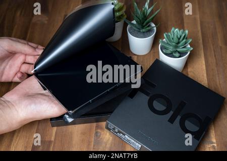 Budapest, Ungheria - 05 gennaio 2023. Samsung Galaxy Z Fold 4 in colore grigio-verde. Un uomo disimballa il nuovo telefono. Foto Stock