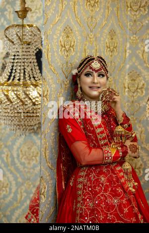 Sposa indiana e pakistana vestita con abiti da sposa tradizionali Foto Stock