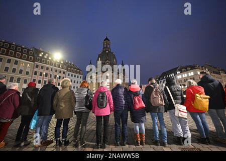 Dresda, Germania. 13th Feb, 2023. I cittadini formano una catena umana su Neumarkt di fronte alla Frauenkirche in occasione del 78th° anniversario della distruzione di Dresda nella seconda guerra mondiale Il 13 febbraio, la capitale dello stato Dresden commemora la distruzione della città nella seconda guerra mondiale 78 anni fa. Il 13 e 14 febbraio 1945, i bombardieri alleati riducevano il centro della città sull'Elba a macerie. Fino a 25.000 persone hanno perso la vita. Credit: Robert Michael/dpa/Alamy Live News Foto Stock