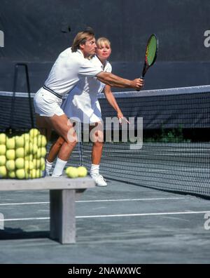 DONNA TENNISTA CON ALLENATORE MASCHILE SUL CAMPO DA TENNIS IN TERRA BATTUTA Foto Stock