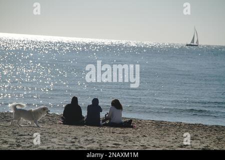 Gaeta, Italia. Le persone che si godono una calda giornata invernale a Serapo Beach. Foto Stock