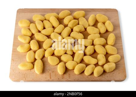 Gnocchi crudi su tagliere di legno isolato su bianco con percorso di taglio. Gnocchi di pasta fatta con farina e patate bollite Foto Stock
