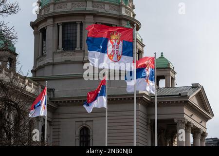 Le bandiere serbe tremano sotto il vento davanti all'Assemblea nazionale di Belgrado, simbolo della Serbia Foto Stock