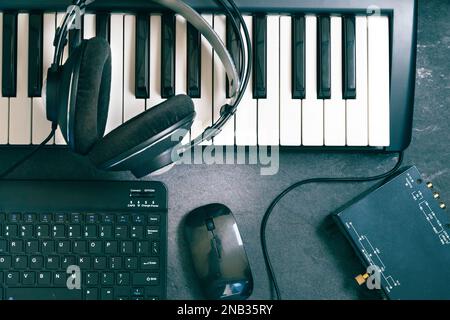 Tastiera o sintetizzatore con cuffie e scheda audio. Concetto di registrazione al computer e produzione musicale.registrazione di musica e studio digitale a casa. Foto Stock