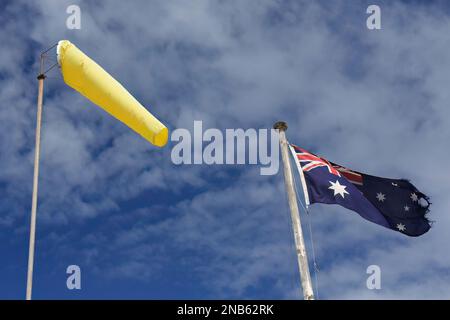 499 calzino a vento giallo e bandiera nazionale australiana che sventola contro il cielo nuvoloso. Manly-Sydney-Australia. Foto Stock