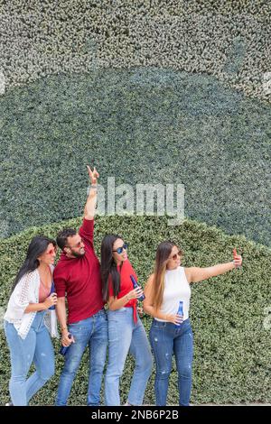 Amici latini che prendono un selfie all'aria aperta Foto Stock