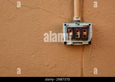 Il vecchio interruttore elettrico arrugginito su una parete Foto Stock