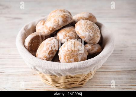 Gustosi biscotti fatti in casa con pan di zenzero nel cestino su un tavolo di legno bianco Foto Stock
