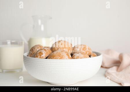 Gustosi biscotti di pan di zenzero fatti in casa in una ciotola su un tavolo bianco Foto Stock