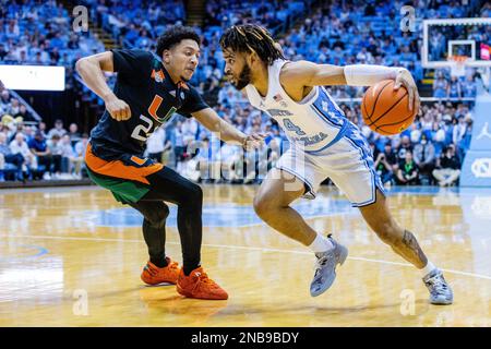 13 febbraio 2023: Miami (Fl) Hurricanes guardia Nijel Pack (24) guardie North Carolina Tar Heels guardia R.J. Davis (4) mentre guida al cesto durante la prima metà del matchup di basket ACC al Dean Smith Center di Chapel Hill, North Carolina. (Scott Kinser/CSM) Foto Stock