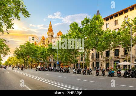 Il sole tramonta sull'edificio Cases Antoni Rocamora e sul viale Paseo de Gracia di fronte a Plaza de Catalunya nel quartiere Eixample, Barcellona Spagna Foto Stock