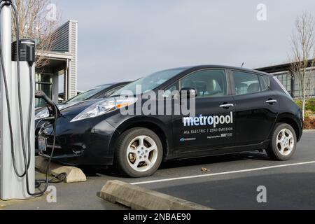 Tukwila, WA, Stati Uniti d'America - 12 febbraio 2023; vista laterale della ricarica di veicoli elettrici a emissioni zero della contea di Nissan Leaf King MetroPool Foto Stock