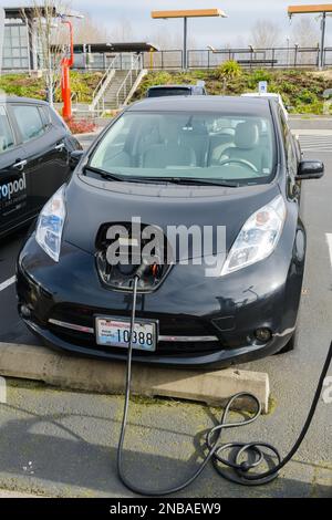 Tukwila, WA, USA - 12 febbraio 2023; Nissan Leaf King County Metro Pool ricarica veicoli elettrici a emissioni zero presso la stazione di Tukwila Foto Stock