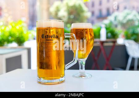 Vista generale di un grande bicchiere di birra Estrella Damm su un tavolo in un bar all'aperto a Barcellona, Spagna. Foto Stock