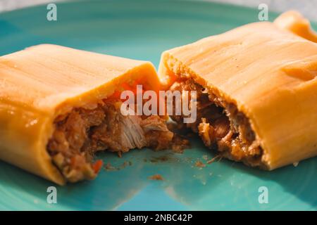 Hallaca o Tamale primo piano su un tavolo rustico e un piatto blu, messicano e venezuelano cibo tradizionale Foto Stock