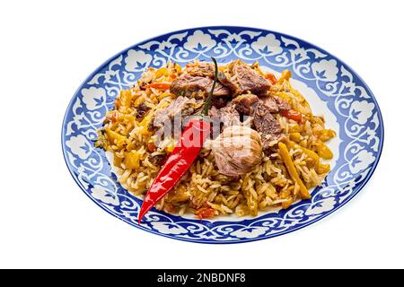 Delizioso pilaf festivo uzbeko in un piatto su uno sfondo bianco isolato Foto Stock