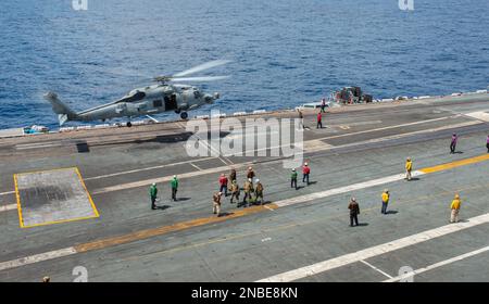 230211-N-WM182-2141 SOUTH CHINA SEA (11 febbraio 2023) un elicottero MH-60R Sea Hawk dei 'Battlecats' dell'elicottero Maritime Strike Squadron (HSM) 73 decade dal ponte di volo a bordo della portaerei USS Nimitz (CVN 68). Nimitz è presente negli Stati Uniti nel 7th Fleet e svolge operazioni di routine. 7th Fleet è la flotta statunitense La flotta numerata più grande della Marina e interagisce e opera regolarmente con alleati e partner per preservare una regione indomorosa e libera. (STATI UNITI Foto Navy di Mass Communication Specialist 2nd Classe Caitlin Flynn) Foto Stock