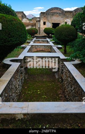 Vista sul giardino e sul sistema di fontana vuoto, in mattoni e pietra nel cortile della villa Praedia di Giulia Felice. A Pompei Archeologico Foto Stock