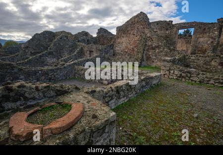 Una vista di una tipica sezione di case in rovina, quartiere, poco più di pali di pietra ruvida, rocce. Nel Parco Archeologico di Pompei vicino a Napoli, Foto Stock