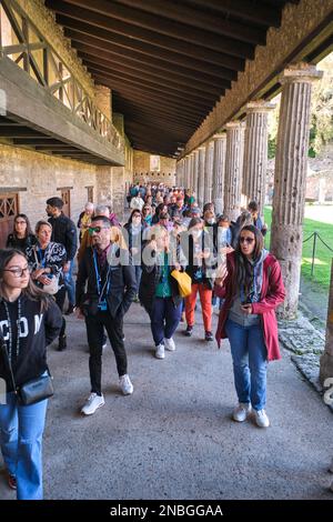 I gruppi di turisti, i turisti, affollano il quadriportico dei Teatri. Al Parco Archeologico di Pompei vicino a Napoli, Italia. Foto Stock